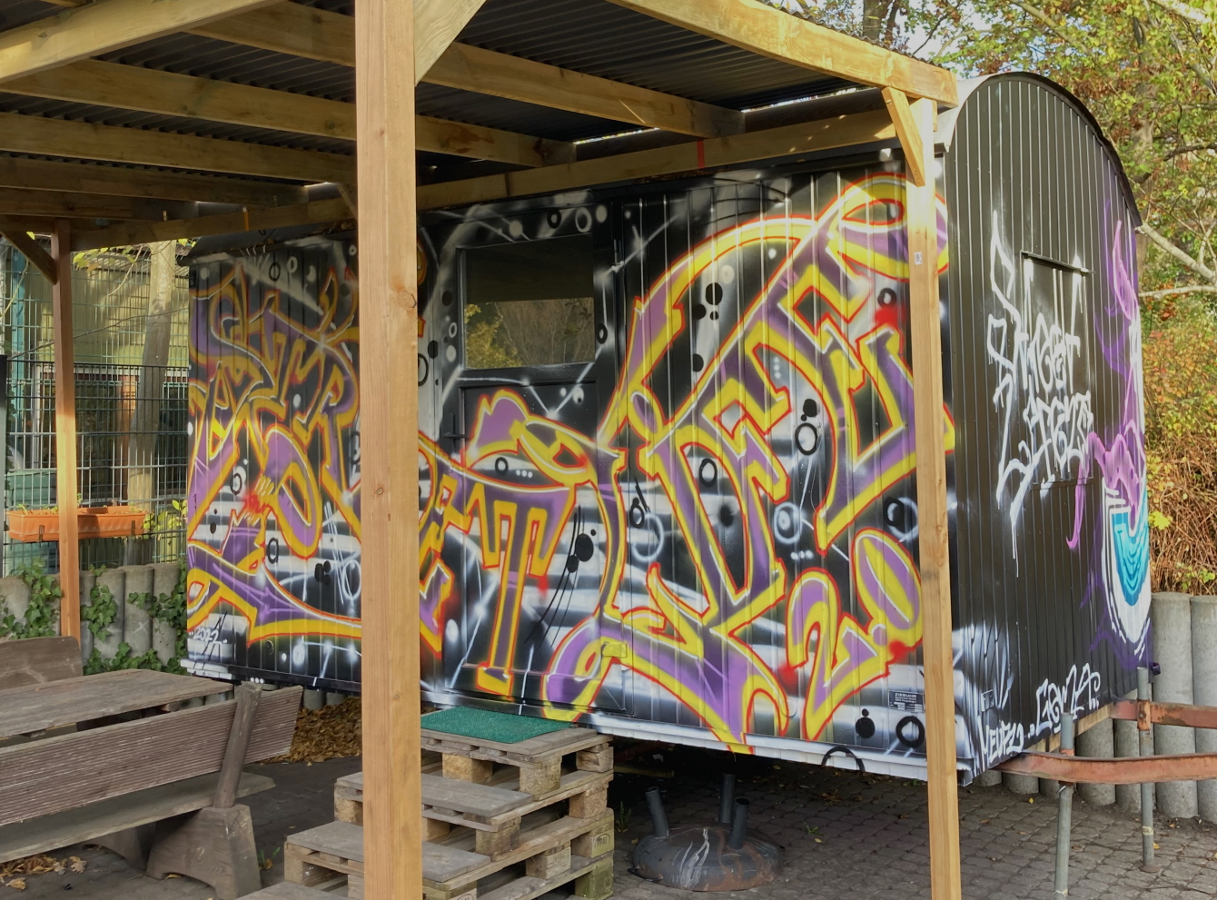Die Seitenwand eines Bauwagens, mit einem ansprechenden Graffiti gestaltet.