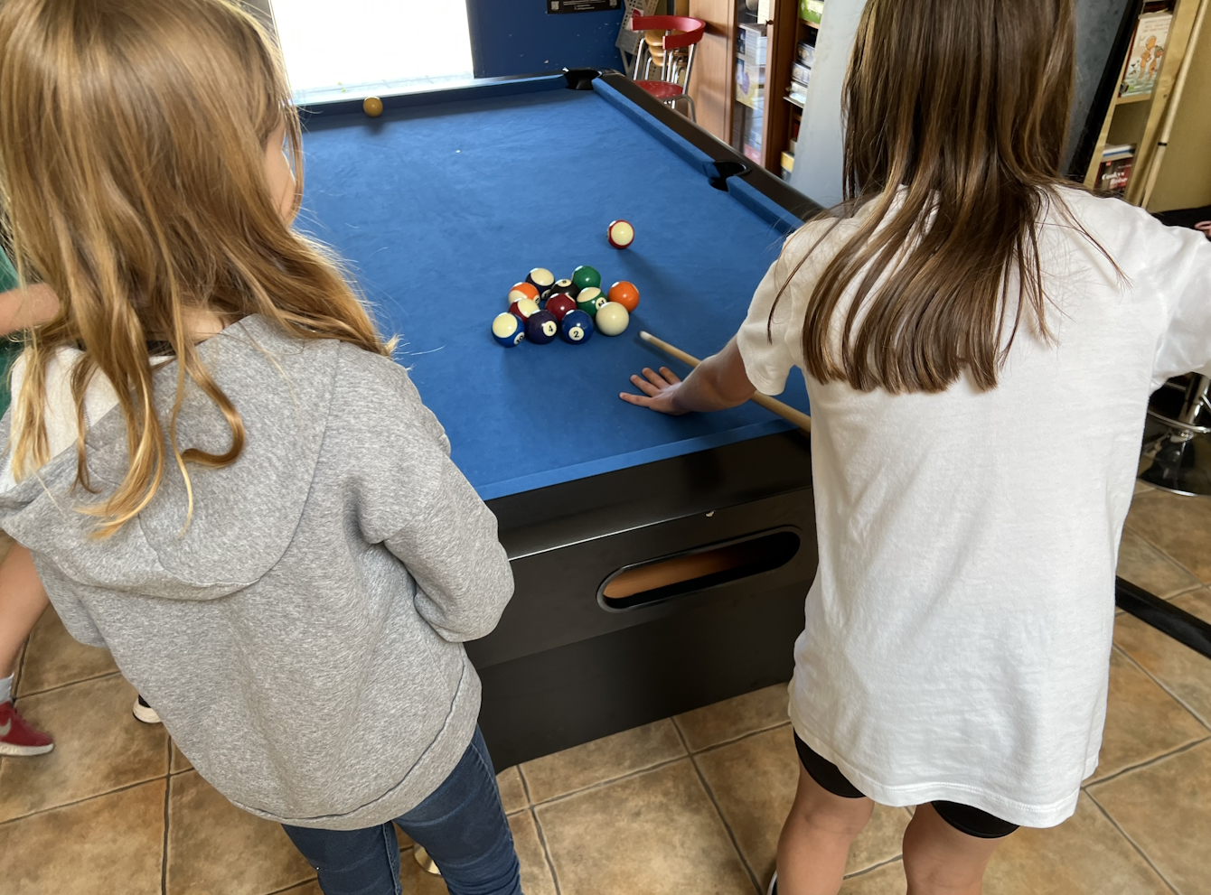 Zwei Mädchen spielen Pool-Billard.