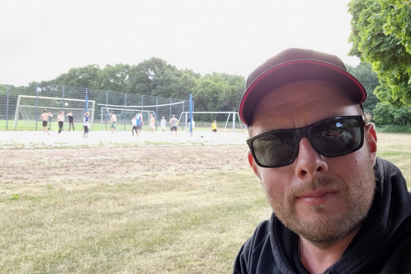 Streetlife-Kollege Jonas mit Beach-Volleyballfeld im Hintergrund