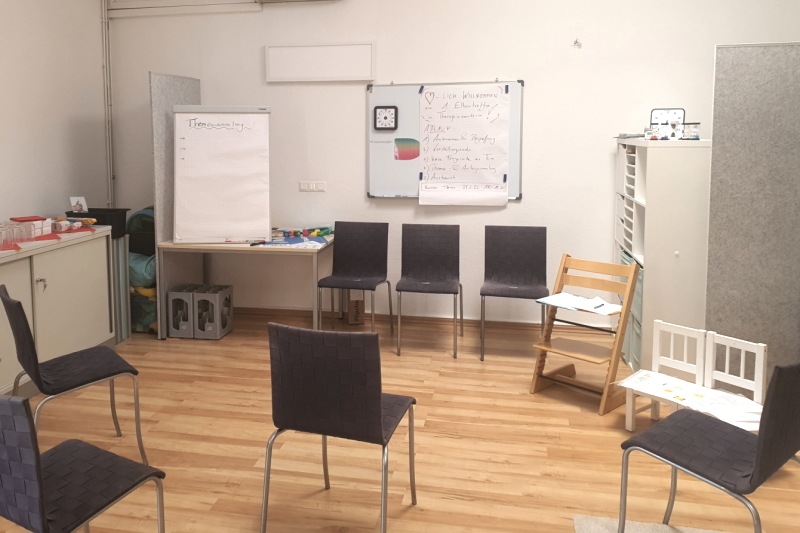 Kleiner Seminarraum mit Stühlen und Pinnwand